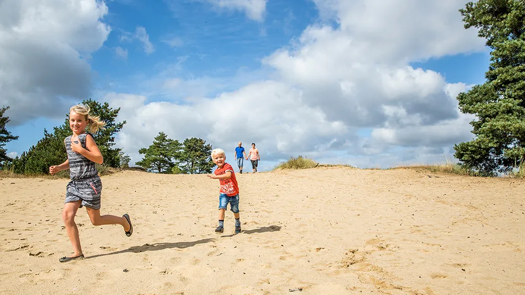Boy and girl running in sand pit