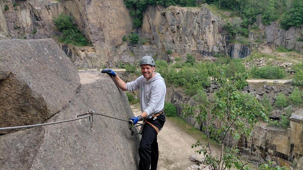 Klatrer på via ferrata-rute i et stenbrud