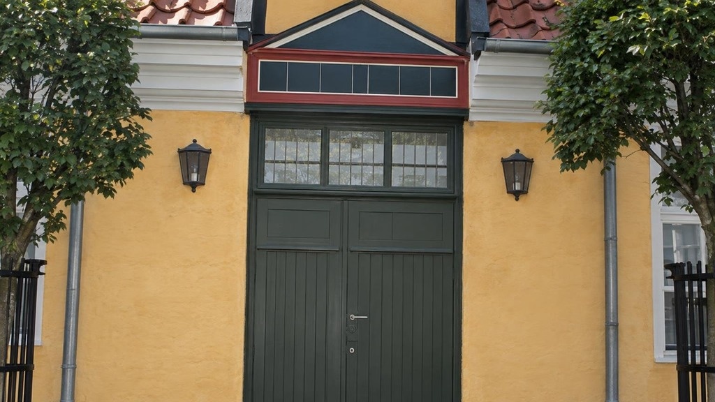 Grøn port i gul facade