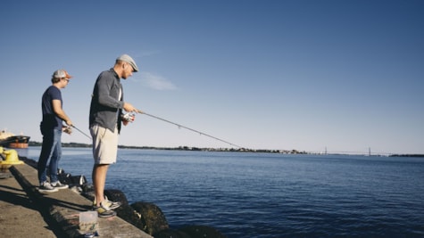 to mænd står og fisker fra havnekanten i fredericia