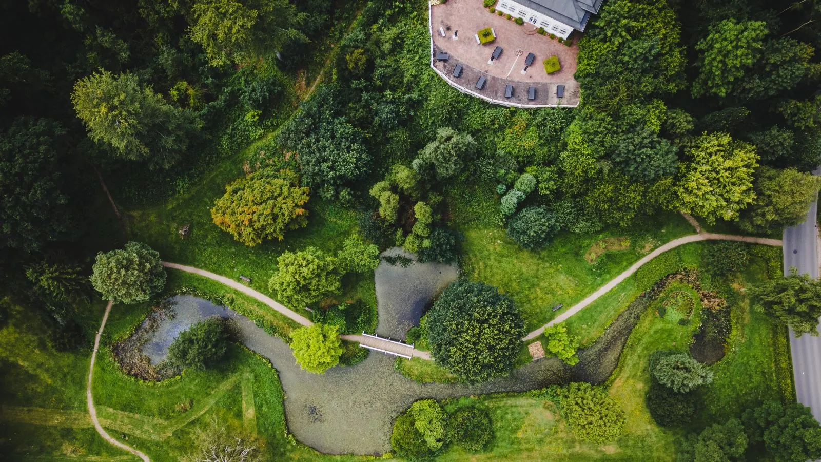 The park at Hannerup House seen from above. Small lakes, paths, and the Hannerup House itself are visible.