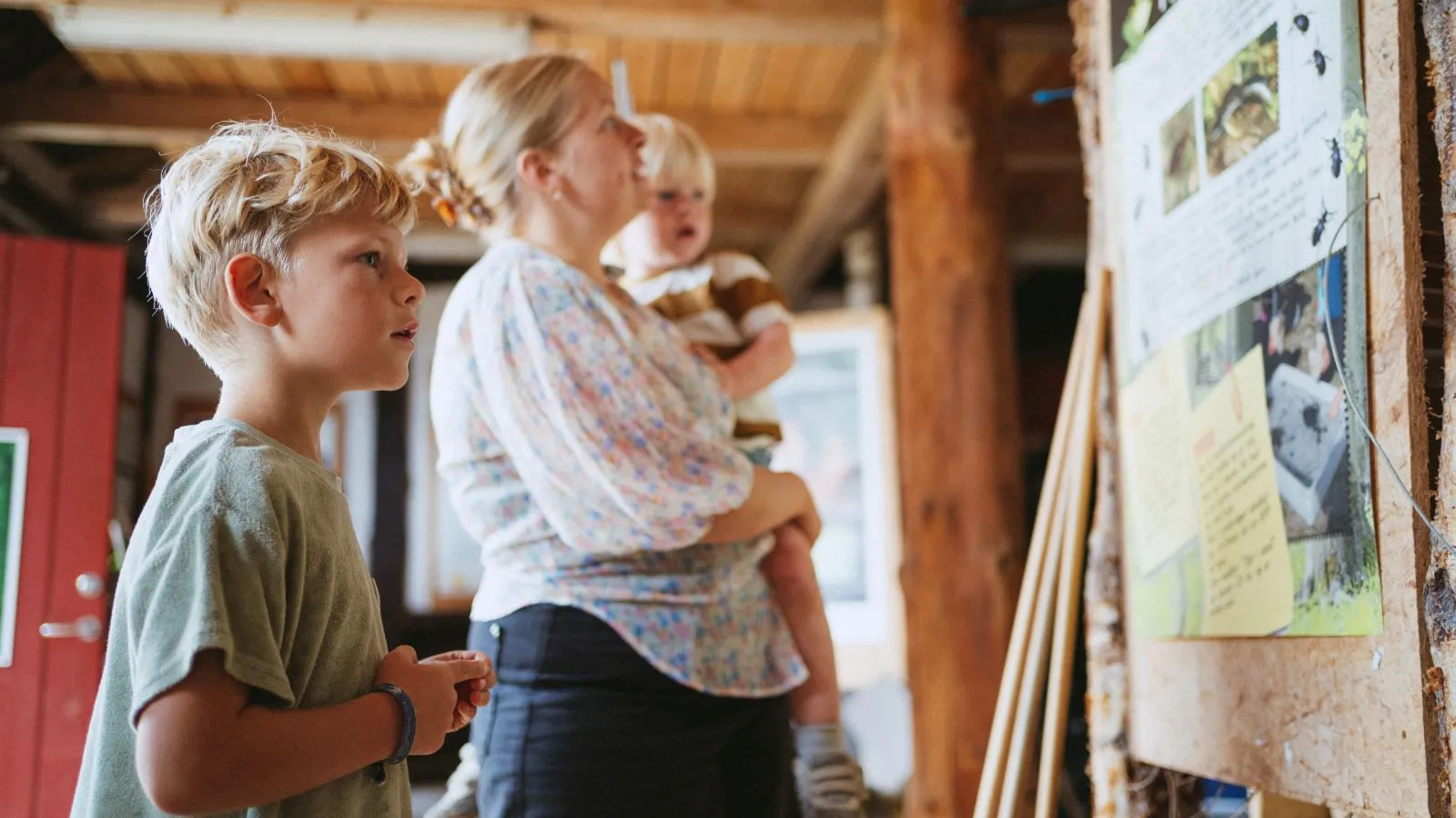 A family walks outside by the Nature Center Trelde Næs. In the foreground, the Nature Center's