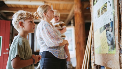 Familie kigger på plakat i Naturcentret på Trelde Næs.