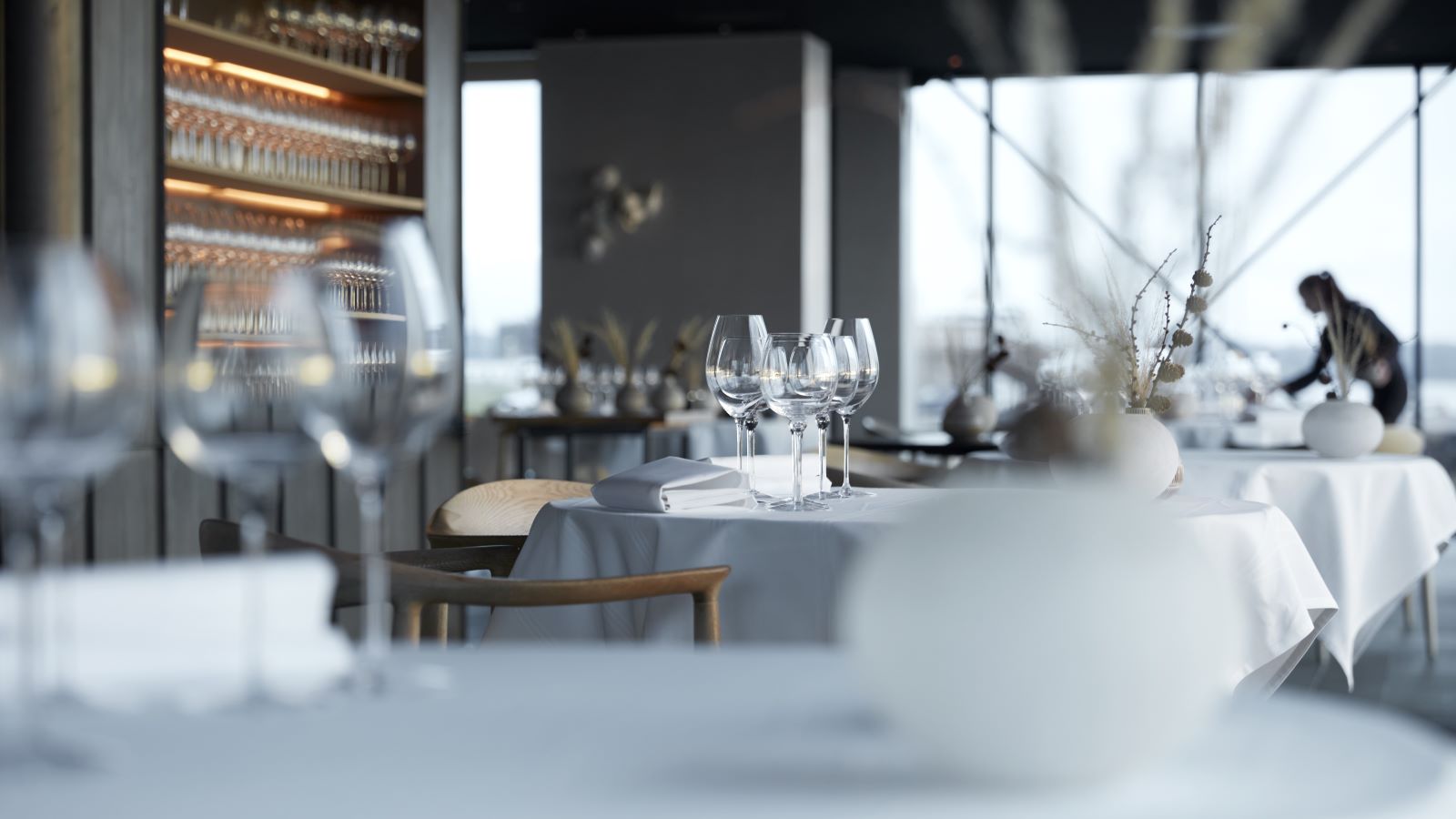 Set table at the restaurant Ti Trin Ned. In the background, a waiter is setting the table.