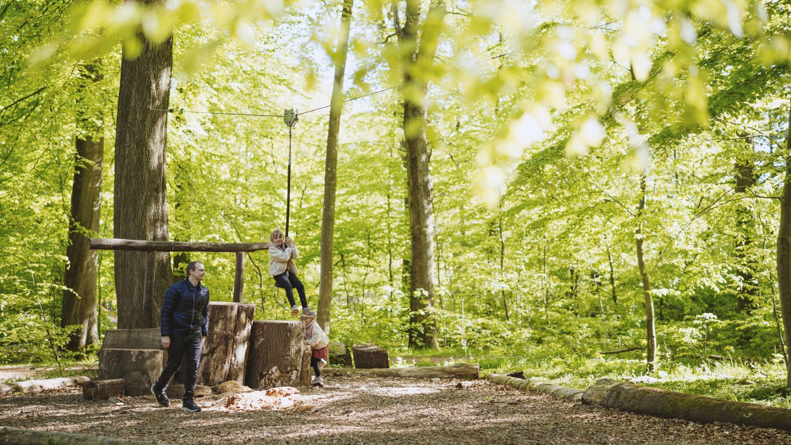 Familie spielt auf einem Naturspielplatz im Fuglsang Skov