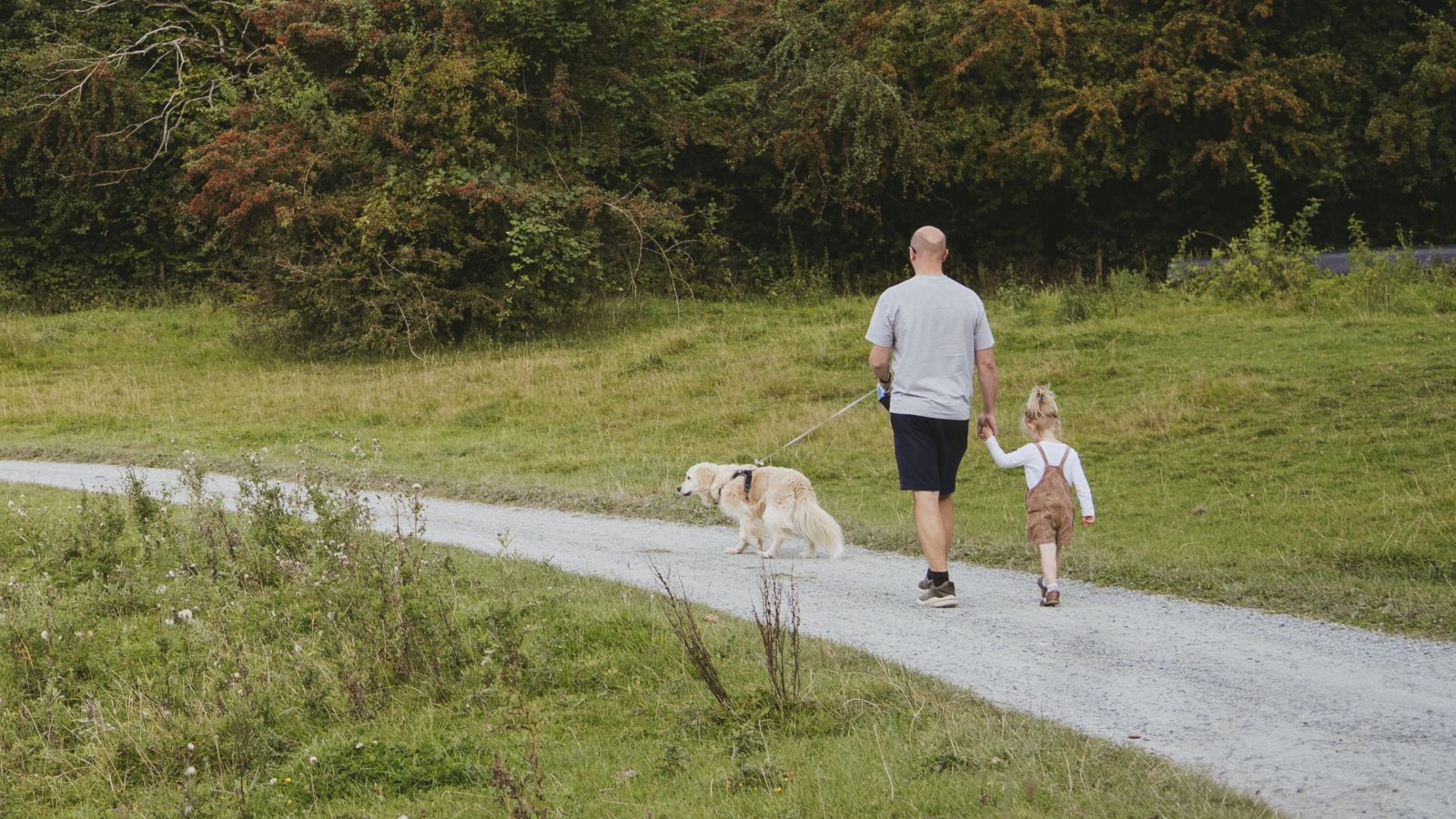 Man and child walking the dog