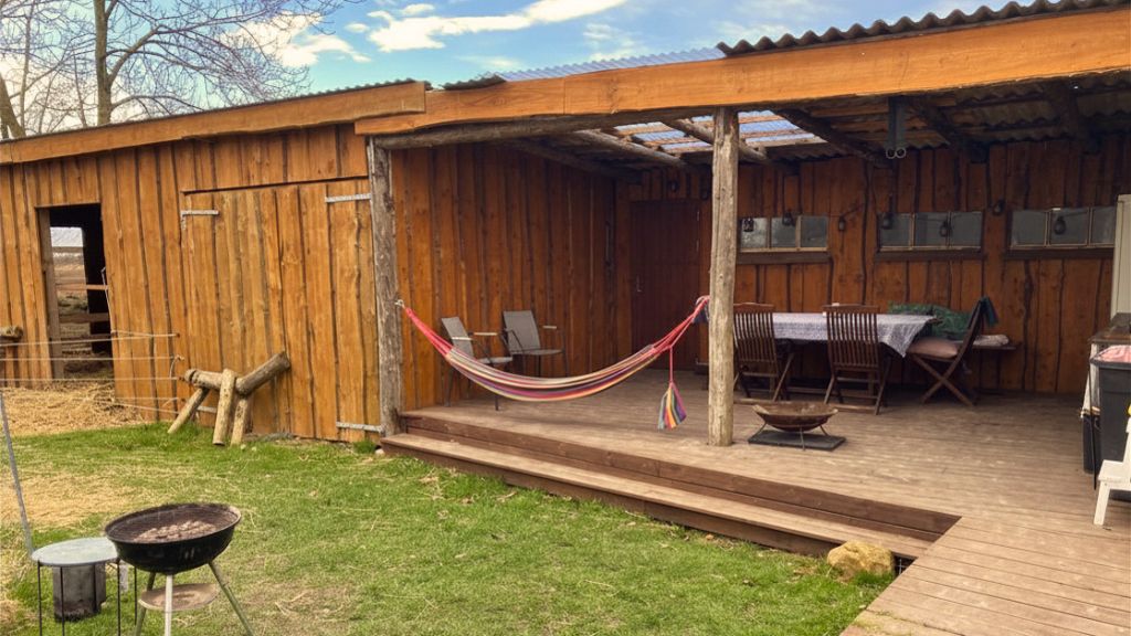Garten mit Hängematte und Stall beim Höhotel in Pejrup