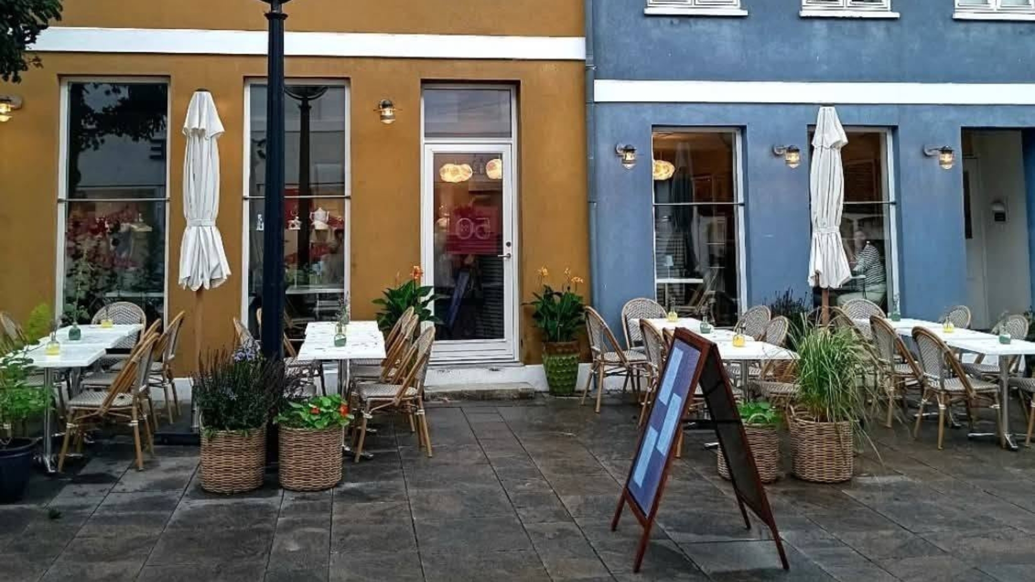 Outdoor seating at Café Himmelblå in Faaborg's pedestrian street with tables, chairs and a welcoming café atmosphere.