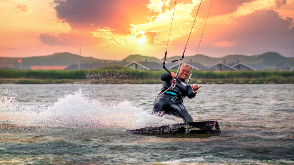 Kitesurfer på board ved solnedgang