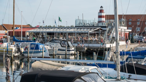 Både ligger til ved marinaen og mennesker går på havnen