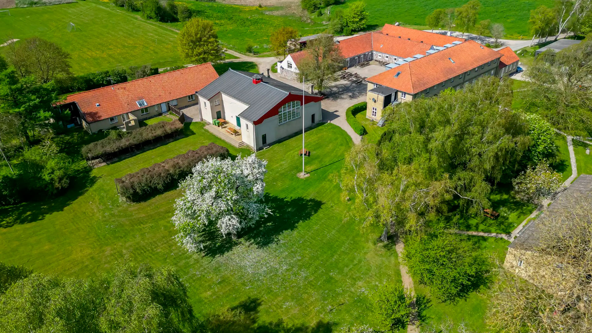 Hovedbygning på Ubberup Konferencegaard i Kalundborg, omgivet af have og grønt — inspirerende ramme til møder og konferencer