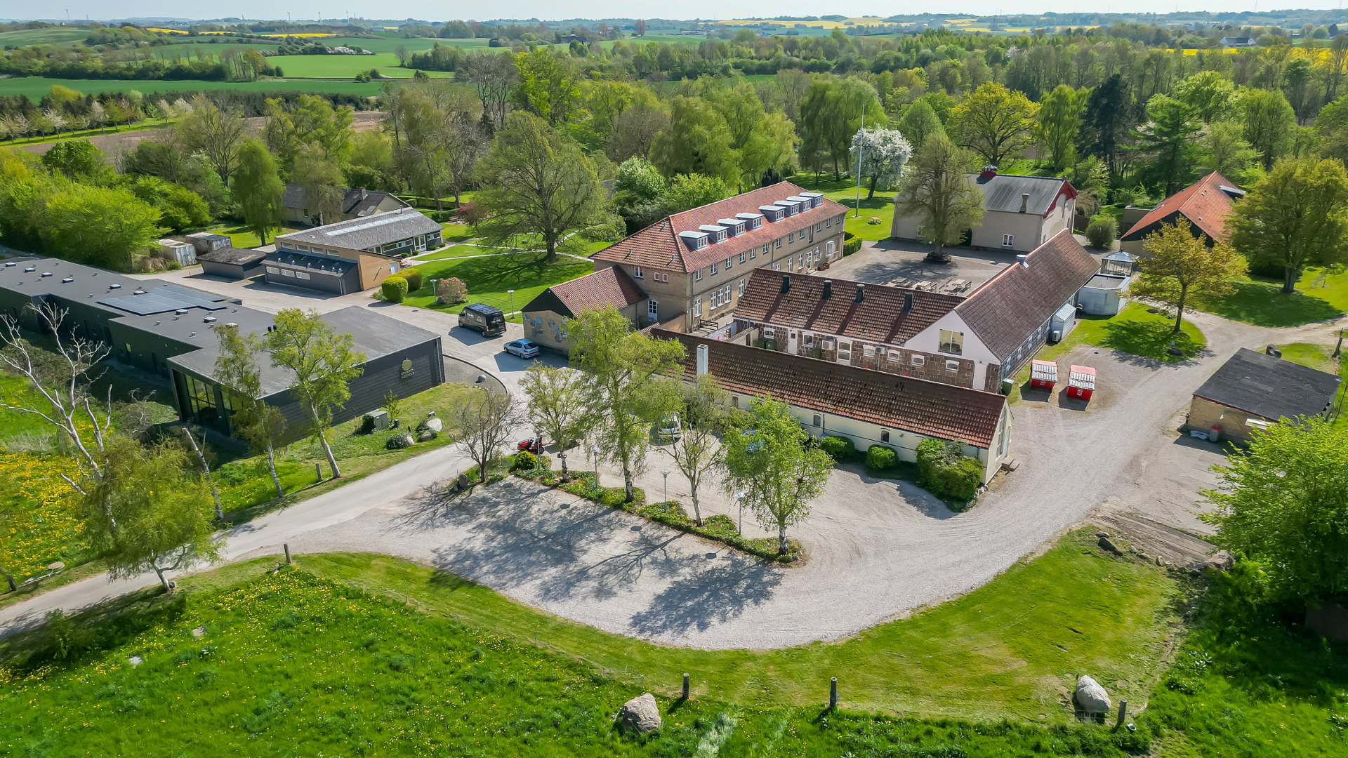 Ubberup Konferencegaard set udefra med den historiske hovedbygning omgivet af grønne omgivelser.