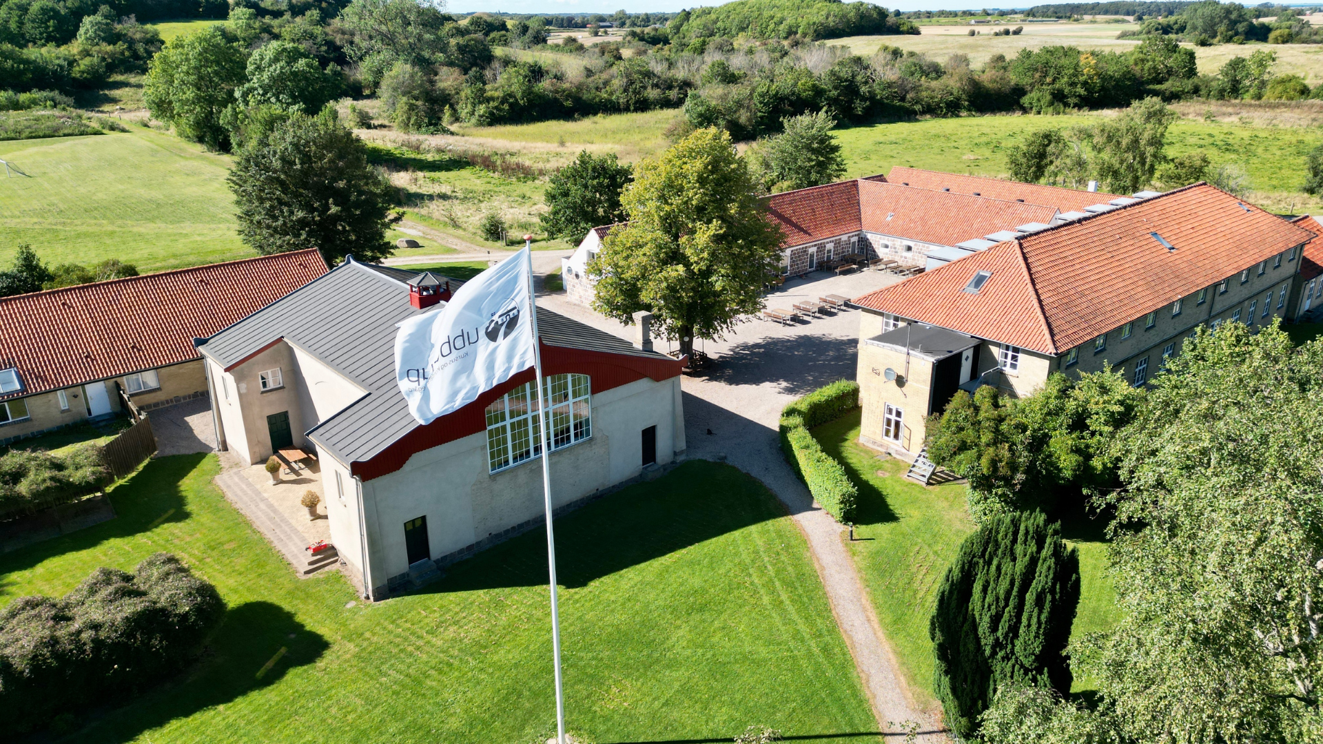 Ubberup Konferencegaard set udefra med den historiske hovedbygning omgivet af grønne omgivelser.