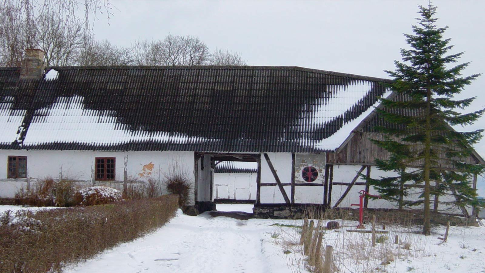 Historisk Kongsgaarden i Vester Broby, en firlænget gård med røde bygninger omgivet af grønne marker og landlig idyl.