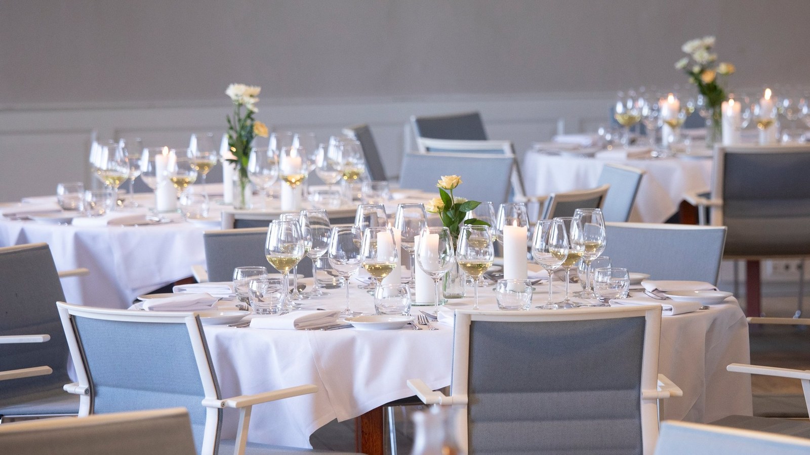 Gedeckte runde Tische im Festsaal des Hotel Strandparken
