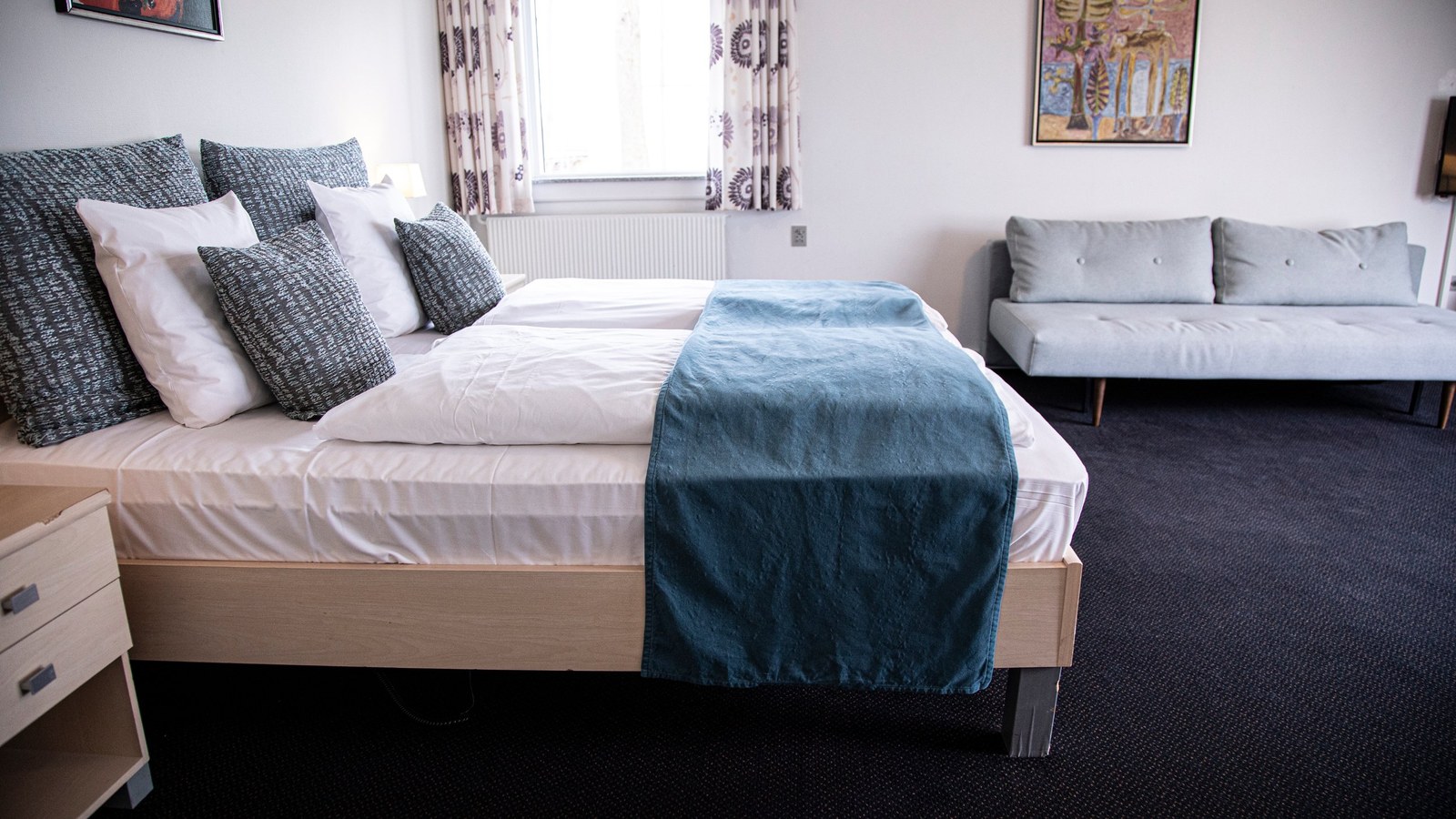 Rummeligt værelse med dobbeltseng og sofa på Hotel Strandparken