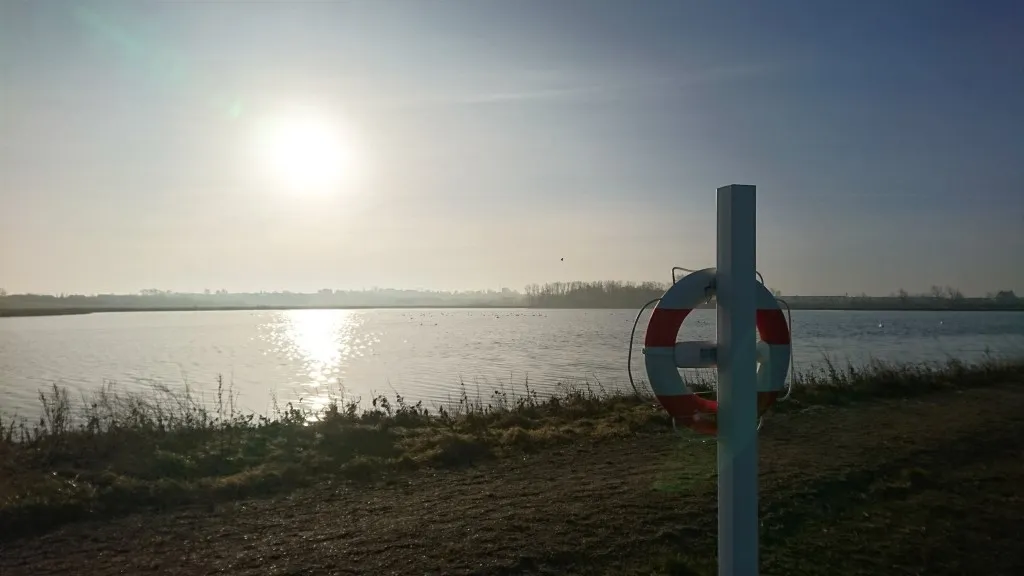 The morning sun over the lake in Sybergland. On the right in the picture, a life jacket.