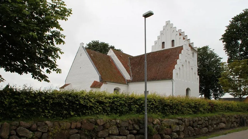 Rynkeby Kirke ses bag hækken