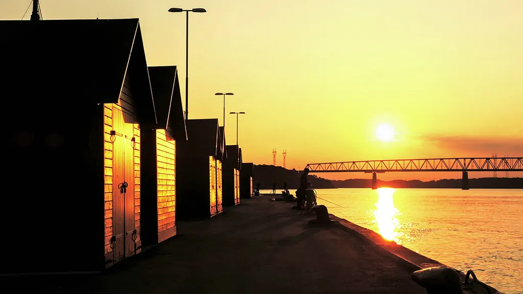 Solnedgang over bådhuse på Gammel Havn.