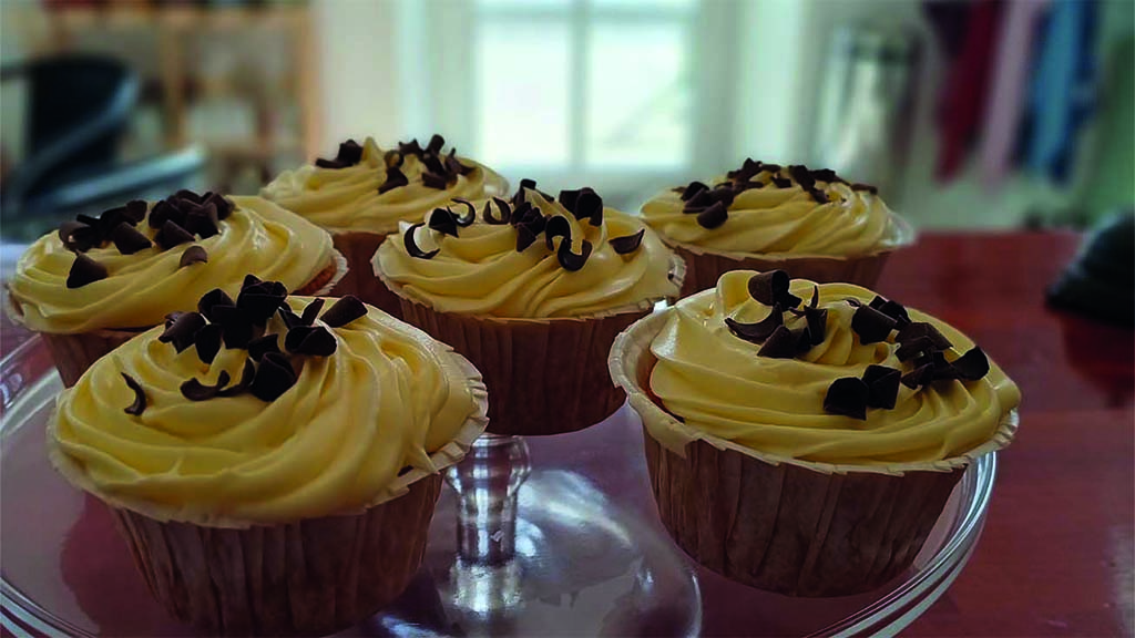 seks muffins med gul frosting på en glas opsats i Aagaardens Café