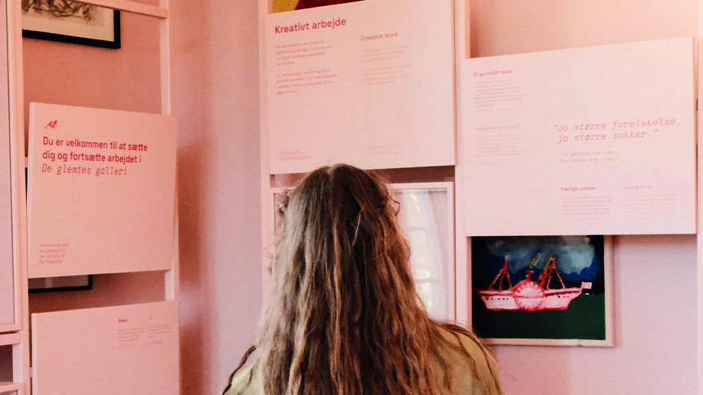 En kvinde kigger på billeder og museums tekster