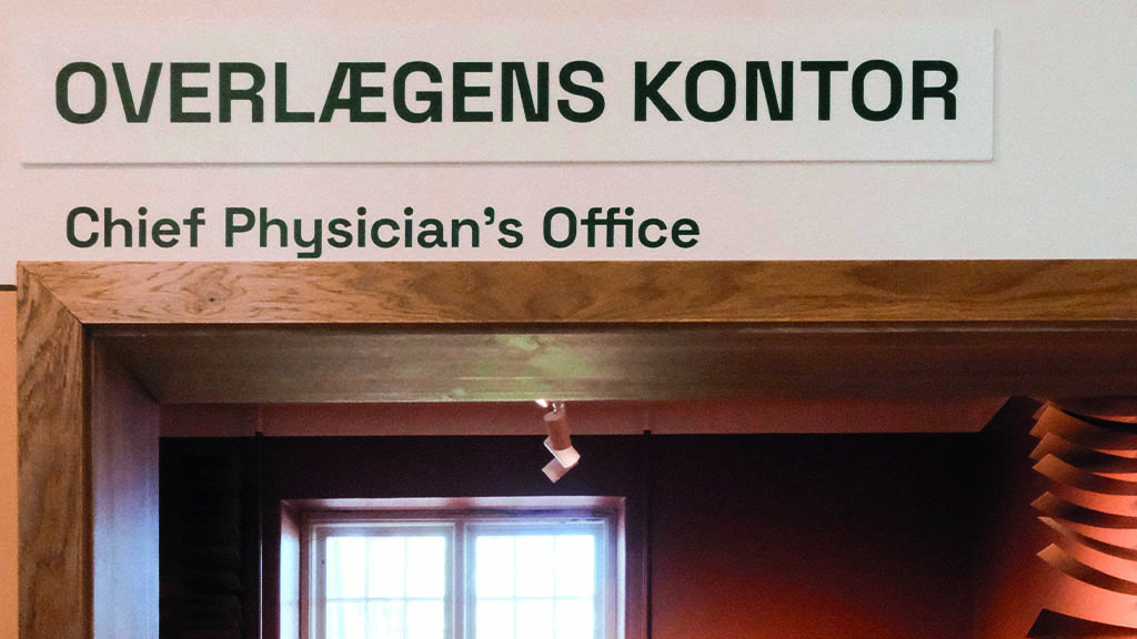 sklit over en kontor dør. Der står "Overlægens Kontor"