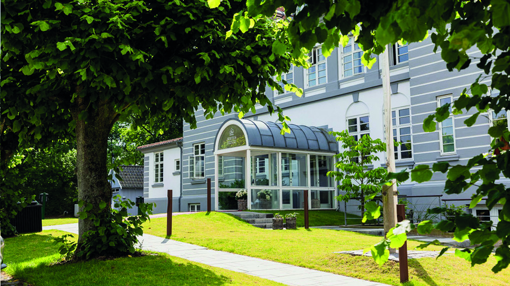 Hovedindgangen ved Hotel Sixtus. indgangen er overdækket. Det er en sommerdag