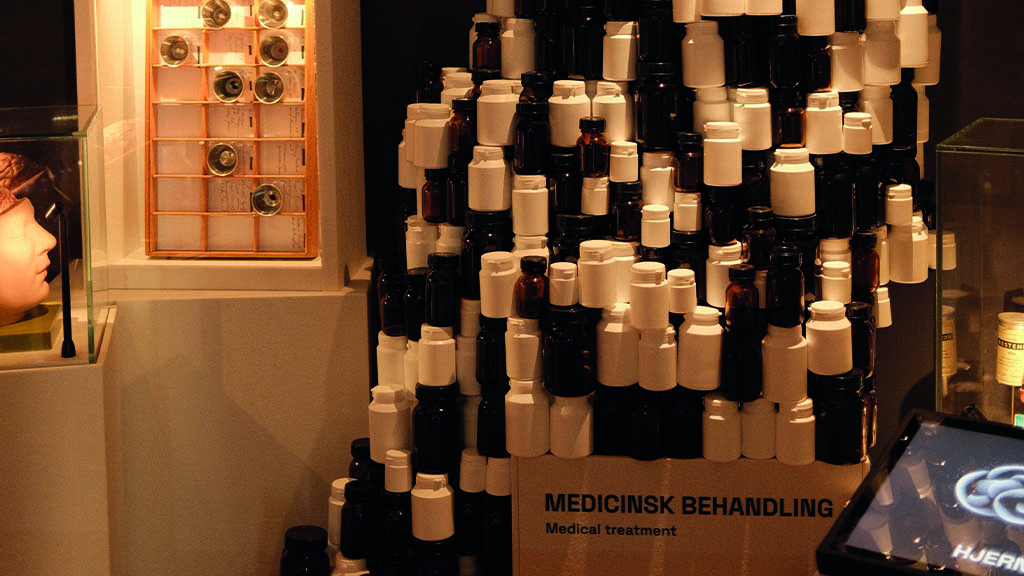 et tårn af pilleglas i en udstilling om medicinsk behandling