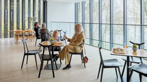 På billedet ses Clay cafe. Der er et stort vindues parti, borde og stole i klassisk design og personer der sidder og spiser.