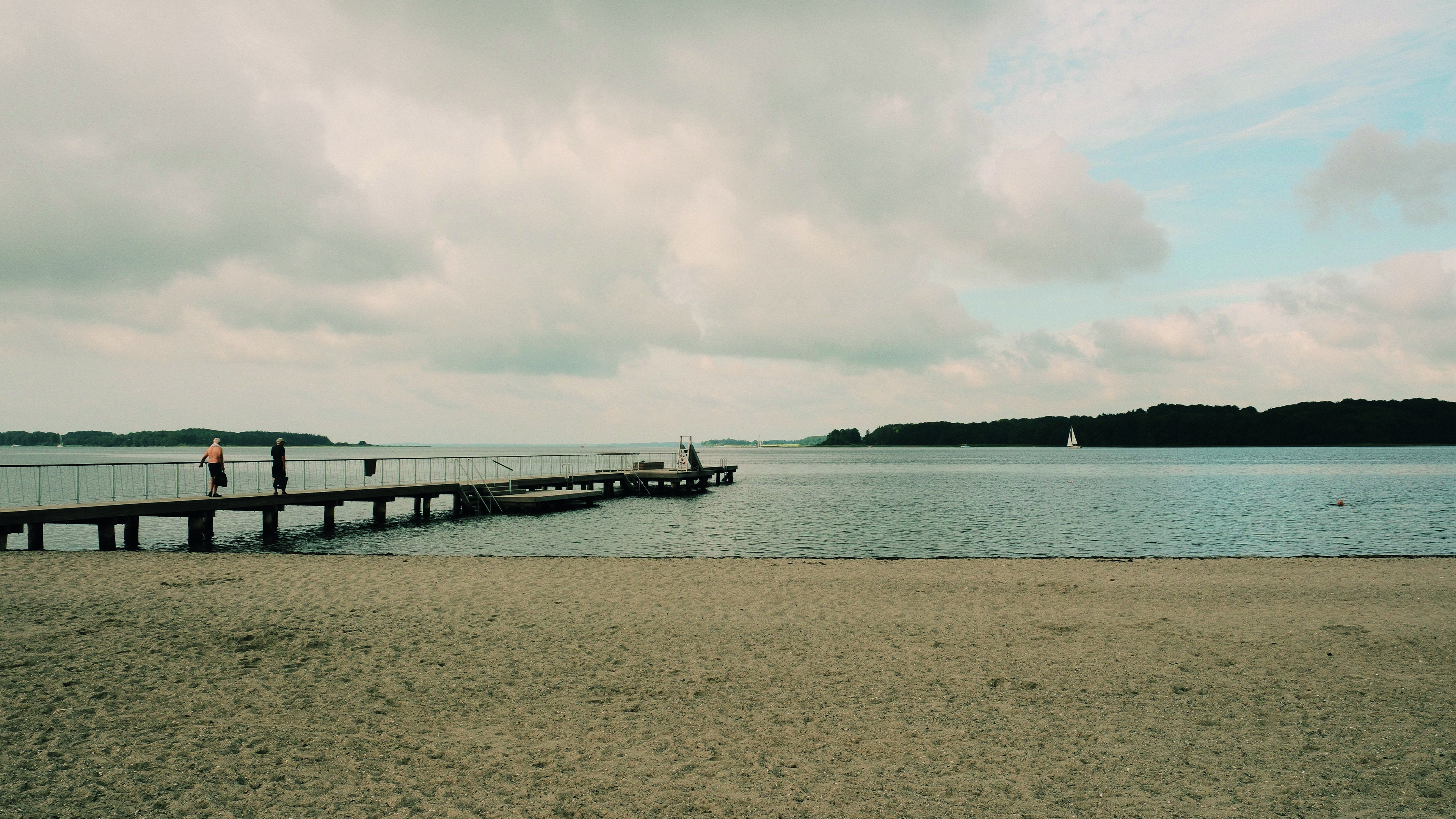 Middelfart marina - bathing jetty - a cloudy summer day. two men are going out for a swim