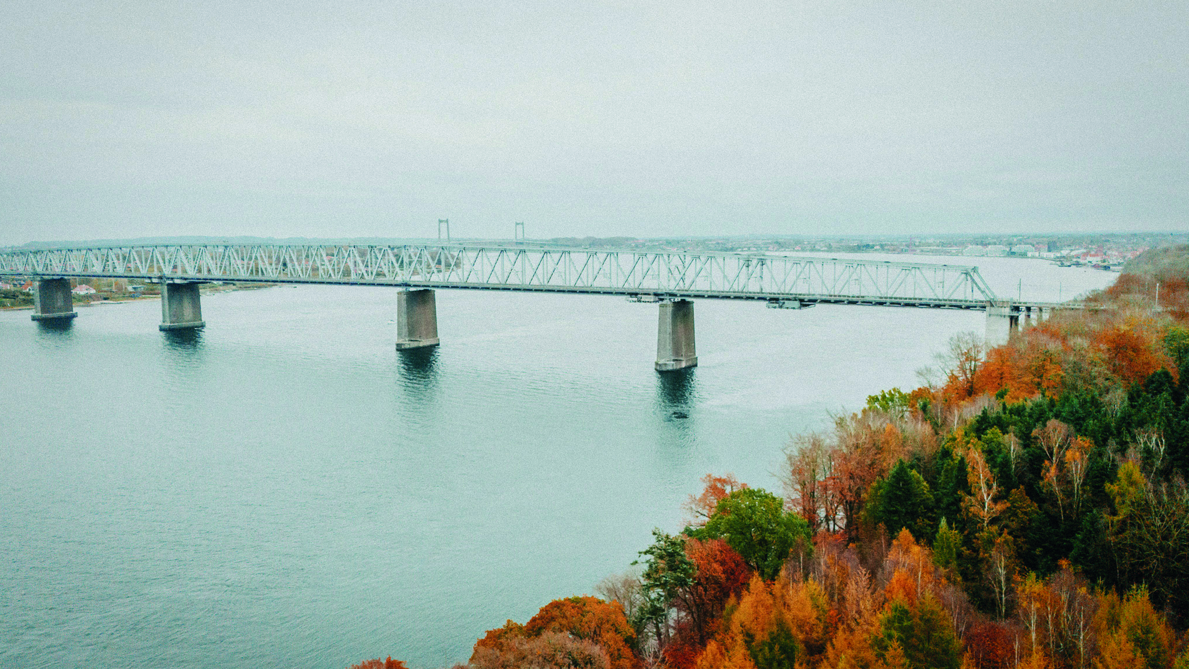 Drone photo of the old Little Belt bridge. An autumn day and the trees are orange
