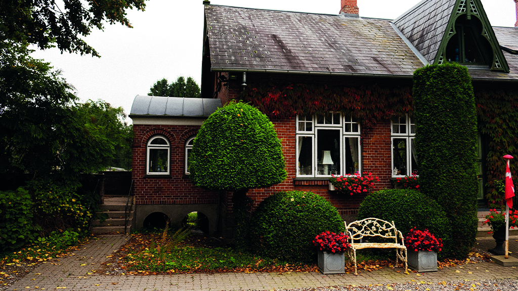 red brick house with climbing plants in red autumn colors