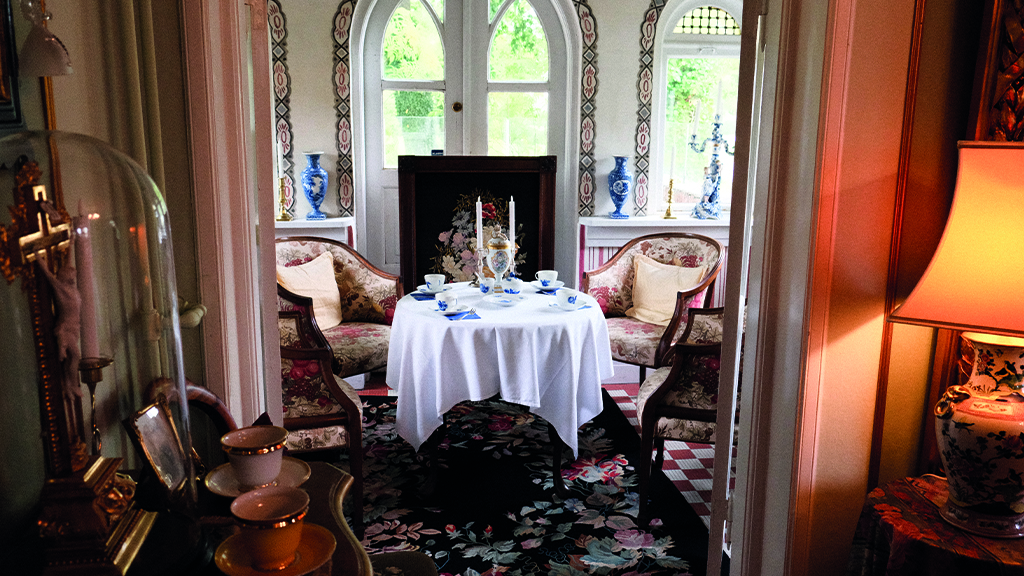 Café in the Humlemagasinet. Tables are set with vintage china, and the space is furnished with antique objects and furniture.