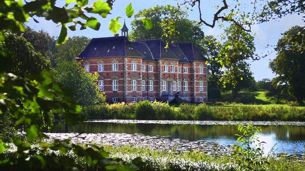 Rugaard Castle and the lake in front in beautiful summer weather