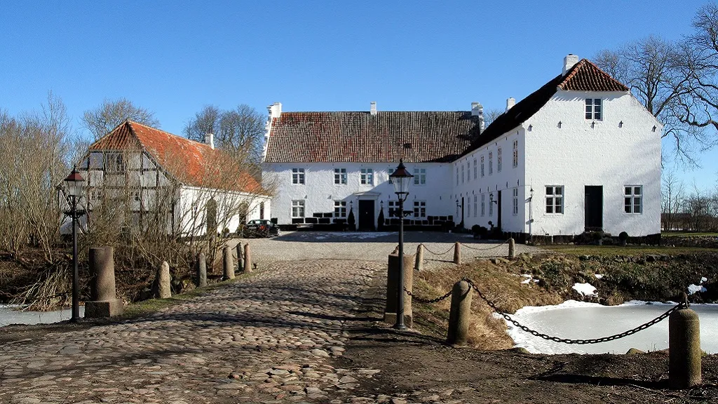 Kørup Castle and the half-timbered building next to it seen from the entrance
