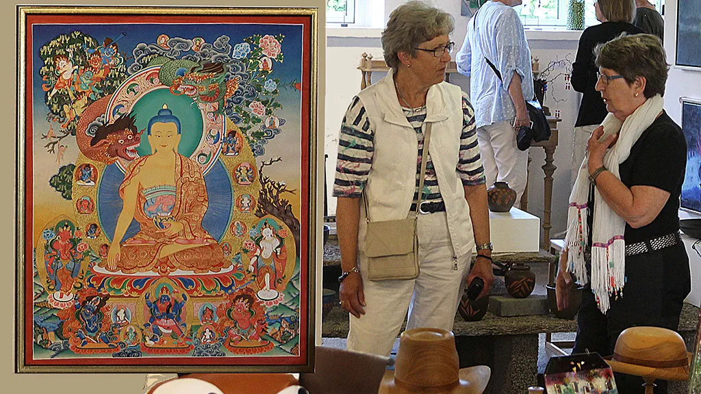 The guests converse by a large painting of the Buddha