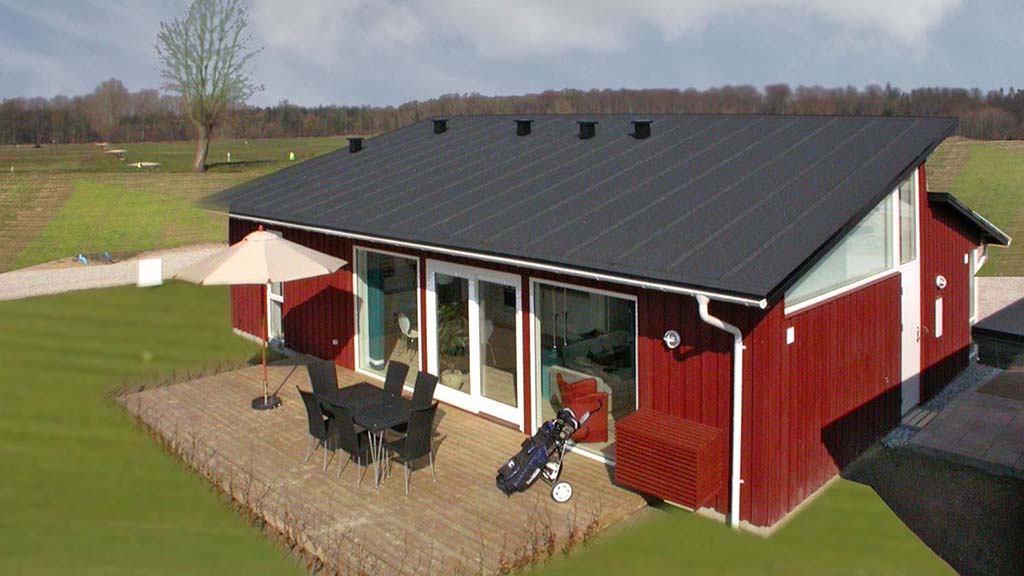 Red holiday house with terrace facing the golf courses in Bogense