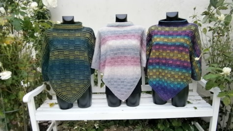3 ponchoer strikket i forskelligt flerfarvet garn fra Butik Hanne i Bogense