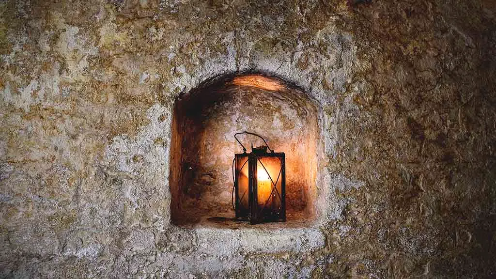 A lamp in one of the old bricked-up windows in the basement