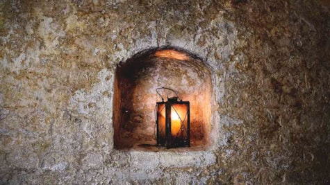 Лампа в одному із старих замурованих вікон у підвалі