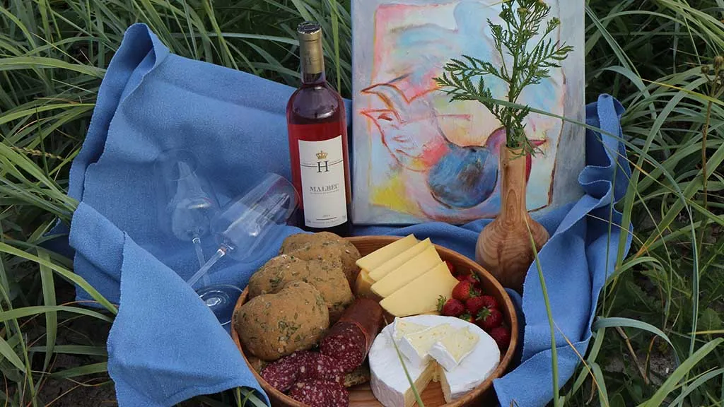 Wooden platter with delicious food, wine and art