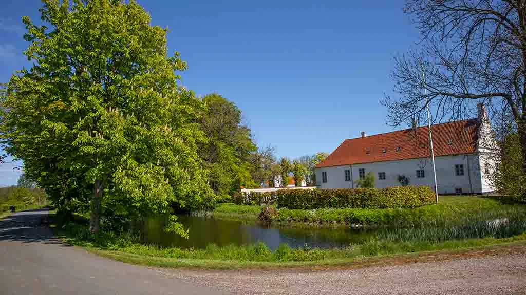 Sandagergaard seen from the road around the moat with the church in the background