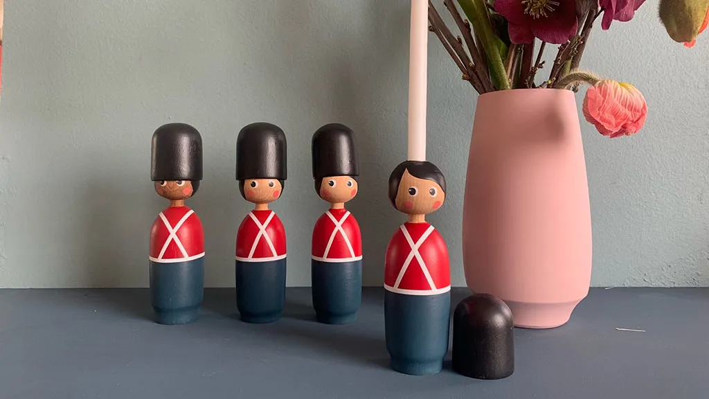 Small wooden soldiers and a pink wooden vase