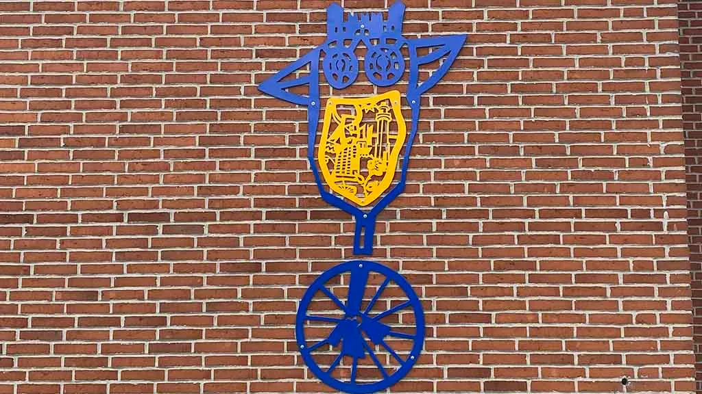 The blue and yellow art relief by Per Buk on the red brick wall