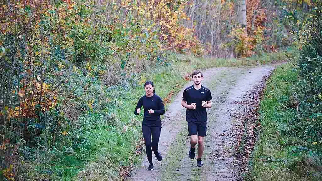 Couple running on the forest road in the Langesø forest