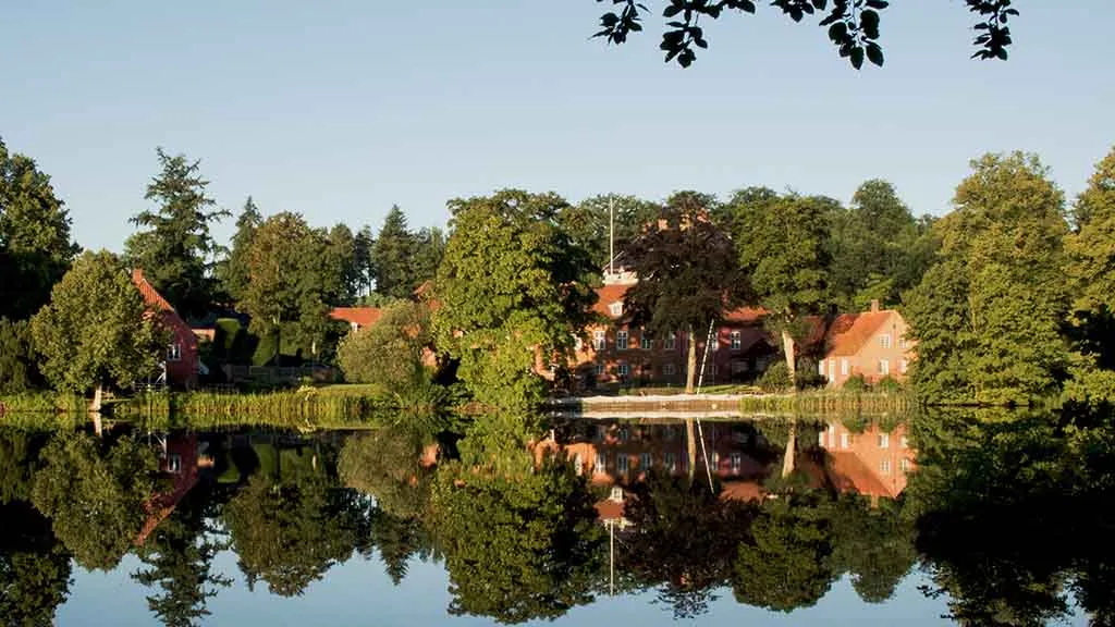 Langesø Castle is reflected in the waters of Lake Langesø