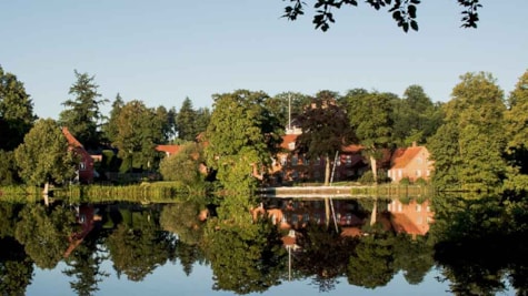 Langesø Slot spejles i vandet på søen Langesø