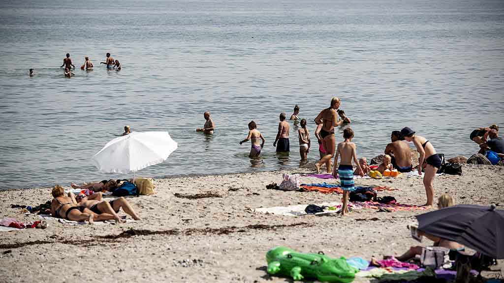 People bathe in the water and relax on Hasmark Beach