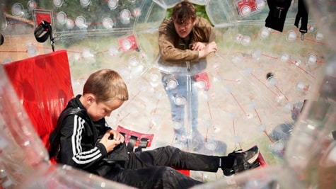 Barn sætter sig ind i zorbing-bold i Fyns Sommerland
