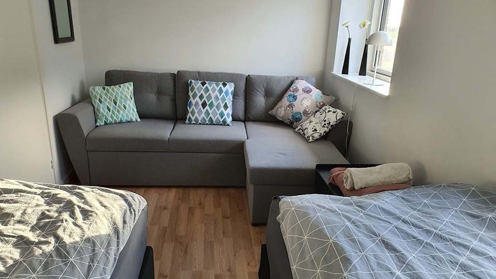 Sofa and two beds in room G in Common House Kirkebakken